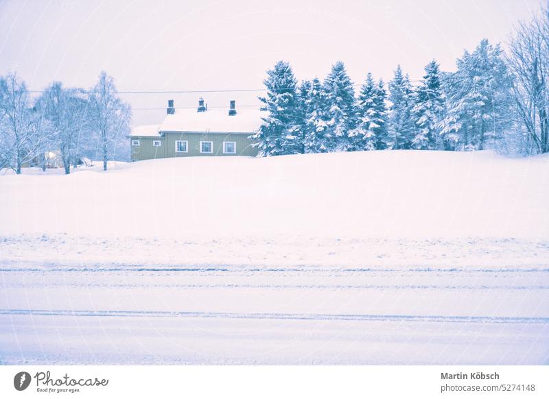 Winter landscape in Scandinavia. Snowy road with snow covered trees and a house winter landscape cold ice light lantern motif path frost weather forest white