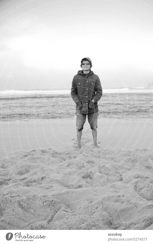 young man standing looking at camera in the beach outdoor ocean male person adult handsome sky guy outside one day sea short shoreline tropical lifestyle