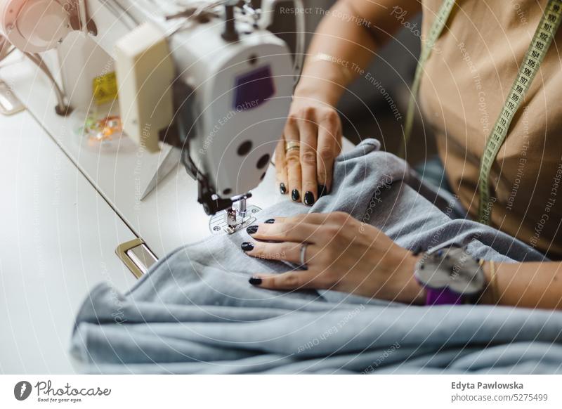 Close-up of a woman's hands sewing on the sewing machine fashion designer craft tailoring manufacturing handmade seamstress small business workshop fabric hobby