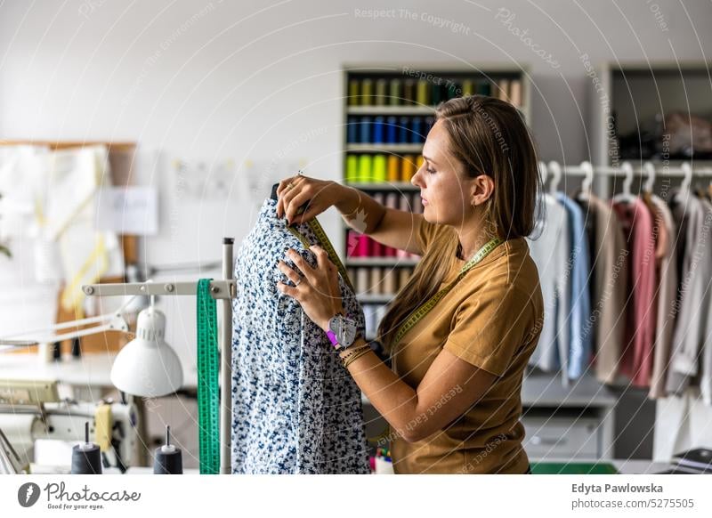 Young fashion designer working at her workplace craft tailoring manufacturing handmade seamstress small business sewing machine workshop fabric hobby clothes