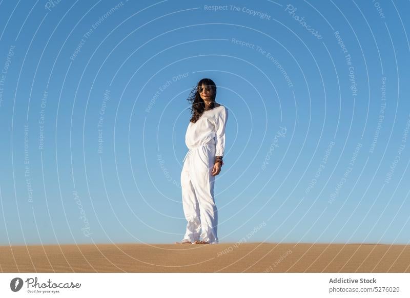 Woman in white clothes standing in desert woman traveler sand blue sky cloudless calm idyllic peaceful heat female frontera dry buenos aires argentina lady wind