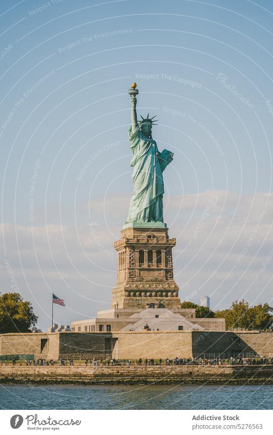 Famous monument on seafront in sunlight statue of liberty embankment cityscape famous water blue sky cloudless landmark river new york liberty island usa