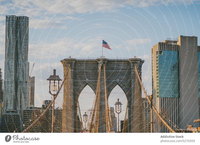 Brooklyn Bridge with flag of USA on top brooklyn bridge cityscape megapolis building sky river architecture skyscraper downtown cloudy america construction