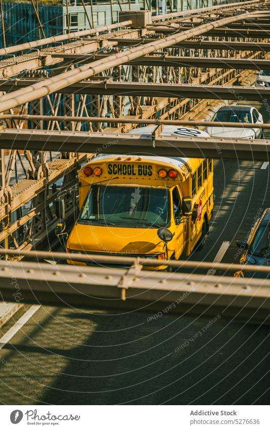 School bus driving on bridge school drive roadway sunny day city sunlight traffic brooklyn bridge new york usa united states america architecture famous attract