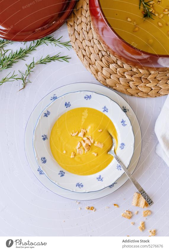 Pumpkin soup puree on white table pumpkin cream saucepan food meal serve cracker plate dish delicious tasty seed ingredient cuisine vegetable yummy gourmet