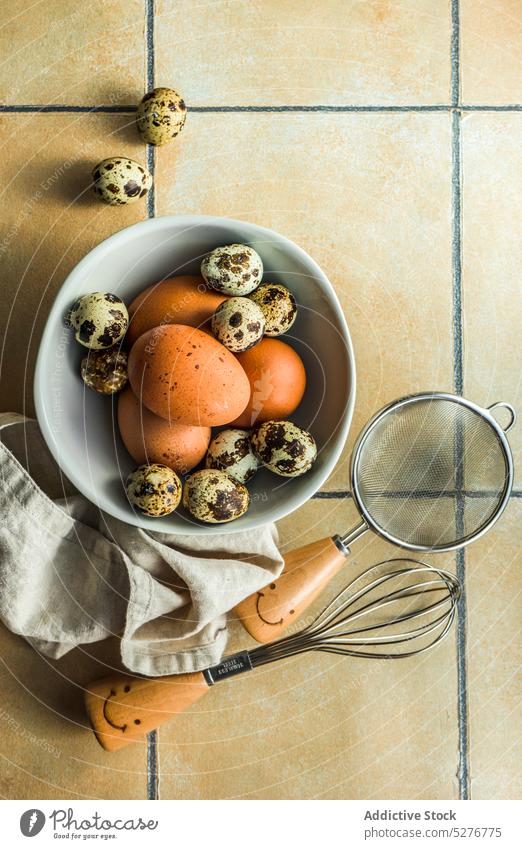 Ceramic bowl with quail and chicken eggs bird black ceramic concrete dark easter food fresh healthy holiday kitchen napkin raw small table tableware utensils