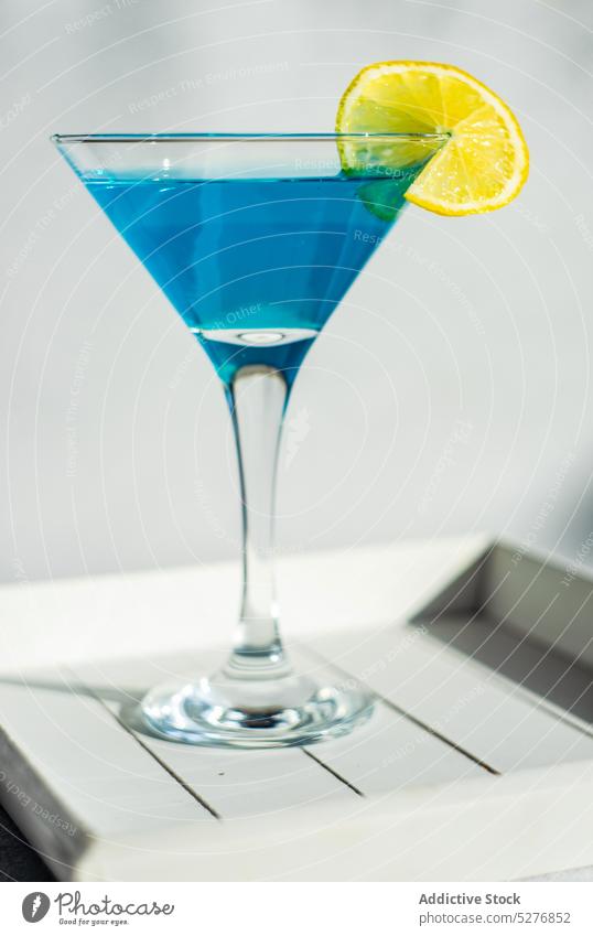 Glass of blue kamikaze drink alcohol alcoholic background beverage cocktail concrete crystal funny glass gourmet ice lemon light liqueur party shot still life