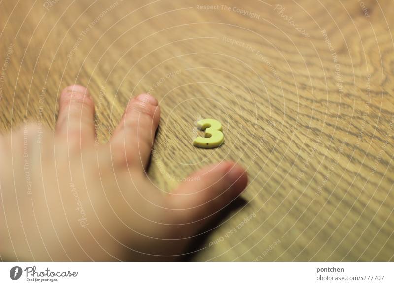 i count to three. three fingers and the number 3 on a wooden table. threat Count to 3 Threaten educate black pedagogy Infancy Parenting Colour photo Numbers