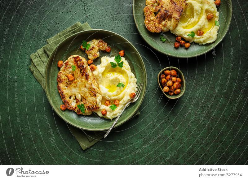 Tasty vegan dish decorated with fresh parsley cauliflower roast potato mashed chickpea spice serve plate vegetarian meal food ceramic culinary puree vegetable