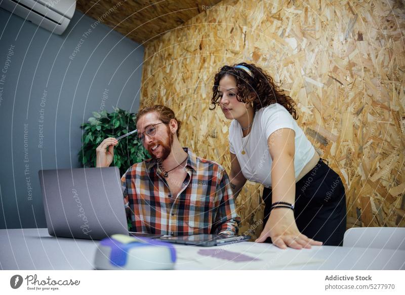 Colleagues working on project using gadgets man woman laptop collaborate coworker thoughtful connection corporate device glasses office browsing job computer