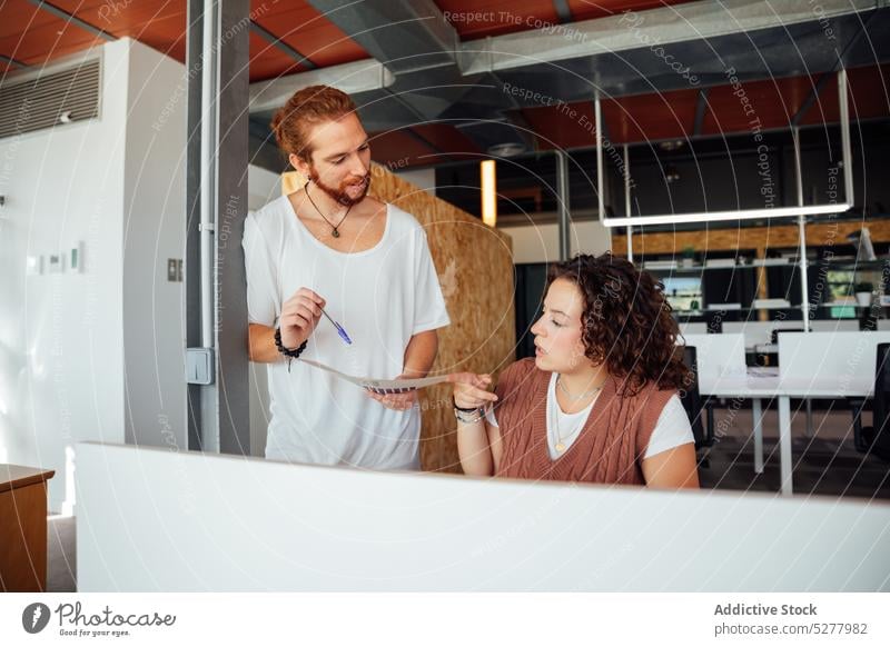 Focused colleagues working with documents in office man woman busy chart paperwork finance diagram laptop collaborate focus business staff coworker project