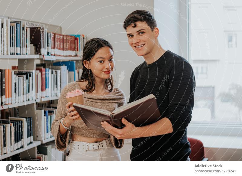 Focused happy students preparing for exam together in library exam preparation read study university concentrate homework learn education young focus coffee