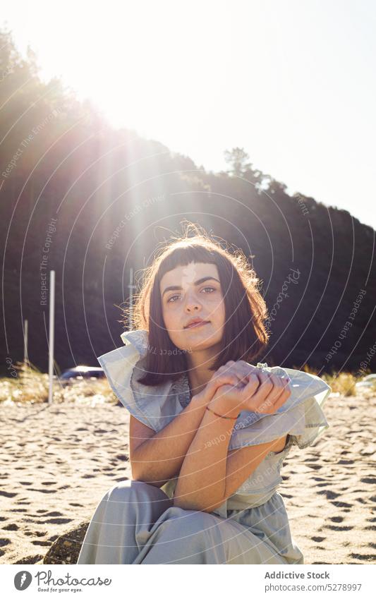 Woman on sandy seashore in sunlight woman beach holiday vacation summer tourist nature female young brunette style dress rest feminine carefree peaceful