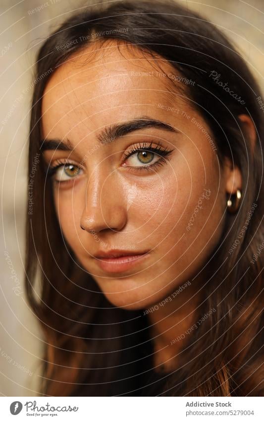 Dreamy young woman looking at camera near stone wall pensive dreamy complexion calm model thoughtful portrait millennial individuality tranquil female long hair