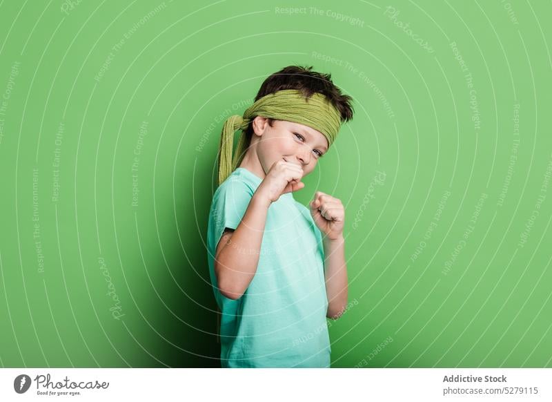 Funny boy clenching fists standing in boxing pose sport studio shot punch defend fighter active clench fist kid child cute funny smile ready healthy boxer