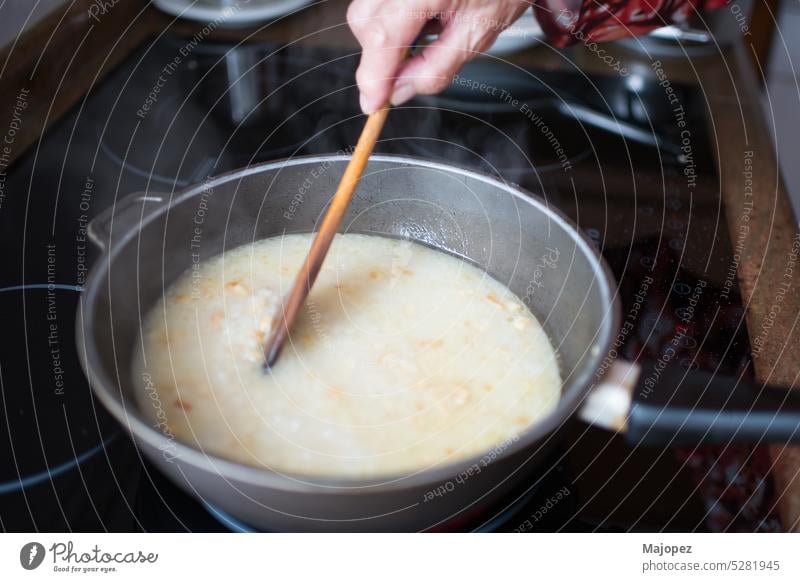 Senior woman stiring rice during cooking tasty homemade hand traditional pot preparation background hot kitchen aged woman caucasian chicken close up copy space