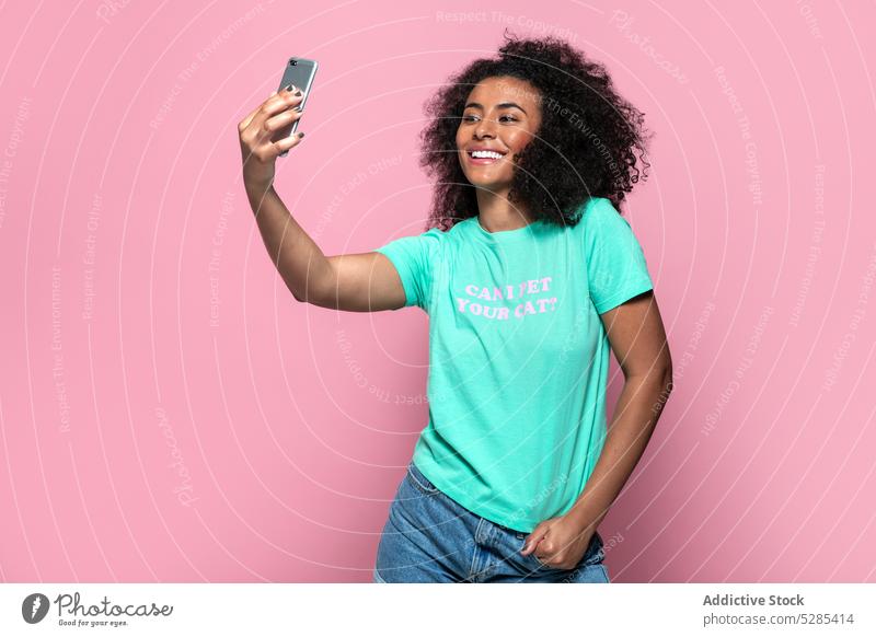 Delighted black woman taking selfie on smartphone music listen headphones smile happy cheerful eyes closed african american female young ethnic device gadget