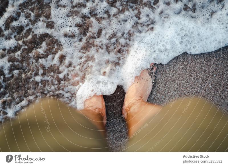 Anonymous man standing in sea water beach resort traveler vacation summer tourist sand barefoot male holiday ocean coast wave trip nature relax shorts tourism