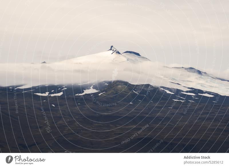 Snowy peak of mountain in clouds snow landscape scenery overcast fog rock nature scenic cloudy majestic iceland ridge range sky environment weather cold