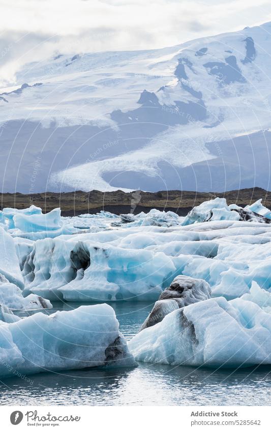 Icebergs floating in sea near mountain range nature scenery iceberg highland landscape water coast rock rocky cliff iceland ocean ripple sky seascape