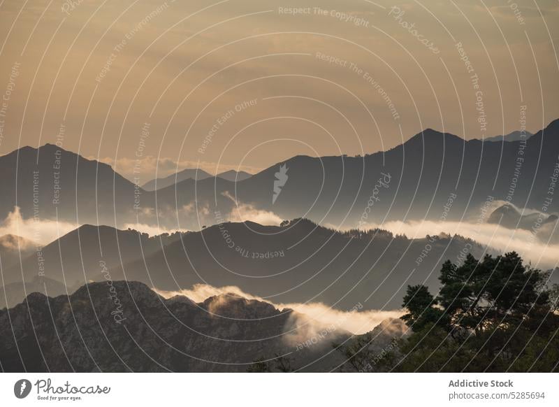 Mountain ridge covered with clouds landscape scenery mountain silhouette sunset nature highland sundown range picturesque environment sky spain peak cloudy