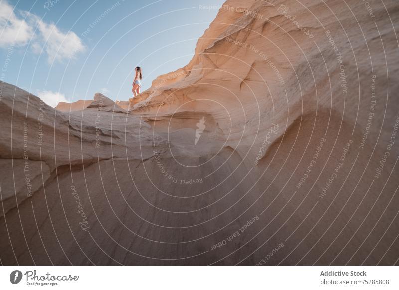 Unrecognizable traveler standing on sandy hill woman desert dune sun landscape nature vacation sunset blue sky dry tourist trip summer idyllic sunlight bright