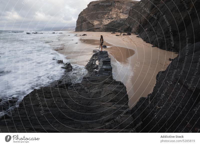 Anonymous female photographer shooting sea standing on rocky cliff woman take photo moment memory photo camera freedom young vacation distance mountain journey