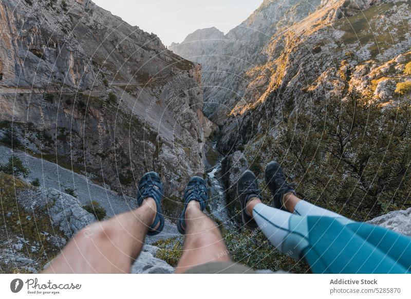 Unrecognizable tourists sitting on rocky cliff traveler mountain trekking hiker admire highland adventure majestic asturias landscape nature spain trip