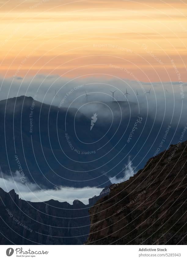 Mountainous area with mist and wind turbines mountain fog landscape environment power energy countryside sunset madeira portugal europe archipelago nature