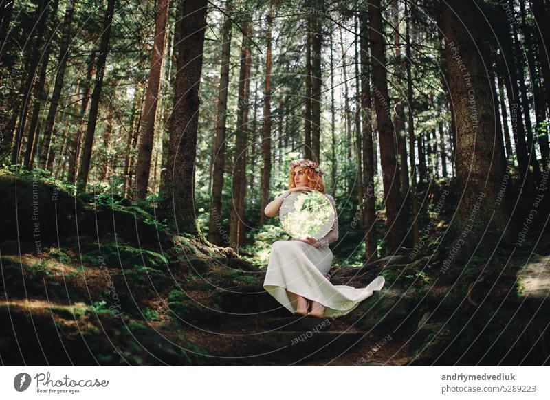 beautiful redhead bride in white dress with a mirror in the green forest woman happy happiness girl nature outdoor people portrait smile beauty summer wedding