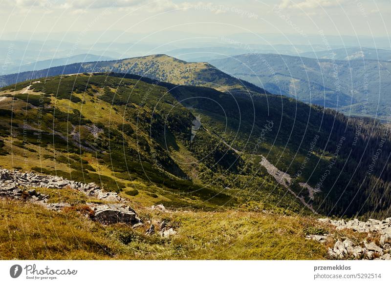 Mountain landscape. Scenic view of mountain peaks, slopes, hills and valleys covered with grass and trees. Panoramic view. Natural scenery nature trip vacation