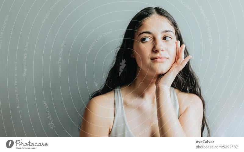 Portrait of model, with hand in face relaxed after dermatology skin treatment. Young adult woman skincare glow from spa rituals, posing with glowing, clean and clear skin and no makeup.