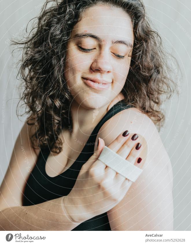 Woman doing a massage with a wooden hand massager. Personal hygiene and body care, morning and evening rituals. Anti cellulite relaxed treatment. young adult