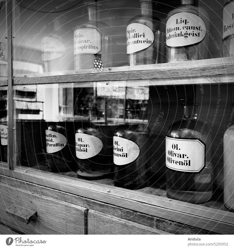 Collection | Oils and spirits in old pharmacist bottles b/w Pharmacy Drugstore Cooking oil Spirits Alcoholic drinks Pharmacy cabinet Bottle pharmacy glass