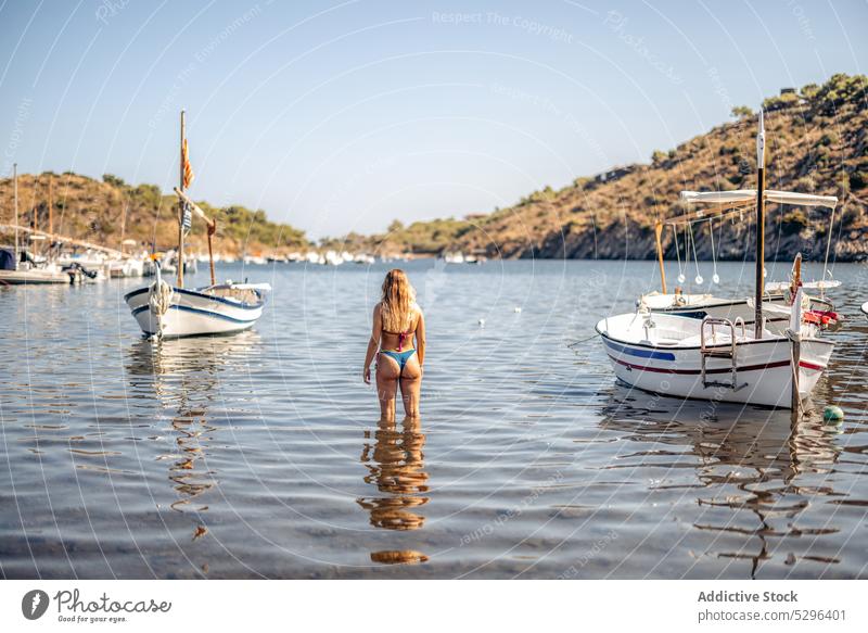 Woman in bikini near yachts admiring view woman tourist boat sea relax vacation cadaques beach admire female girona spain travel adventure freedom ocean coast