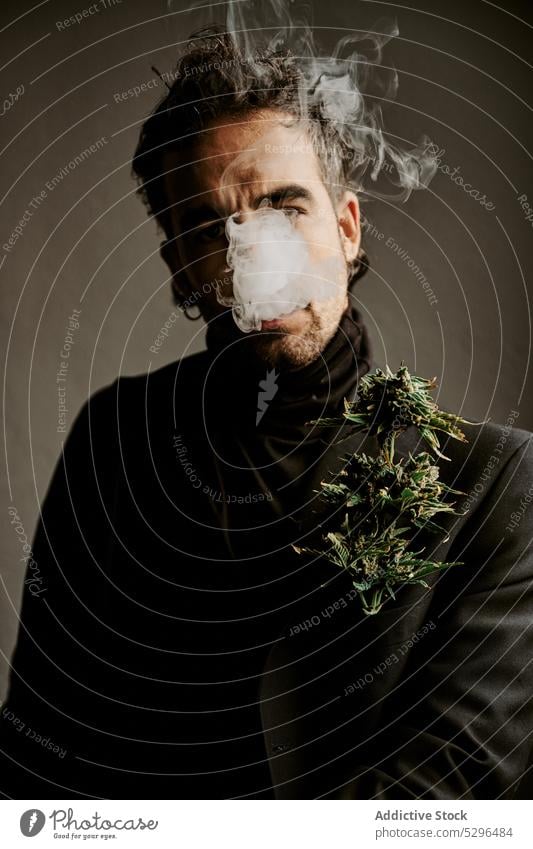 Bearded man smoking marijuana in dark room smoke cigarette smoker inhale exhale habit addict drug adult male dark hair enjoy fragrant brunet herb medical ganja