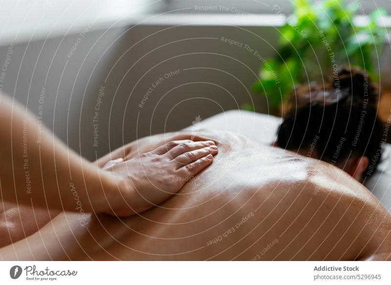 Crop therapist doing body massage to female client in spa salon women back relax masseur procedure rehabilitation therapy treat specialist patient calm care