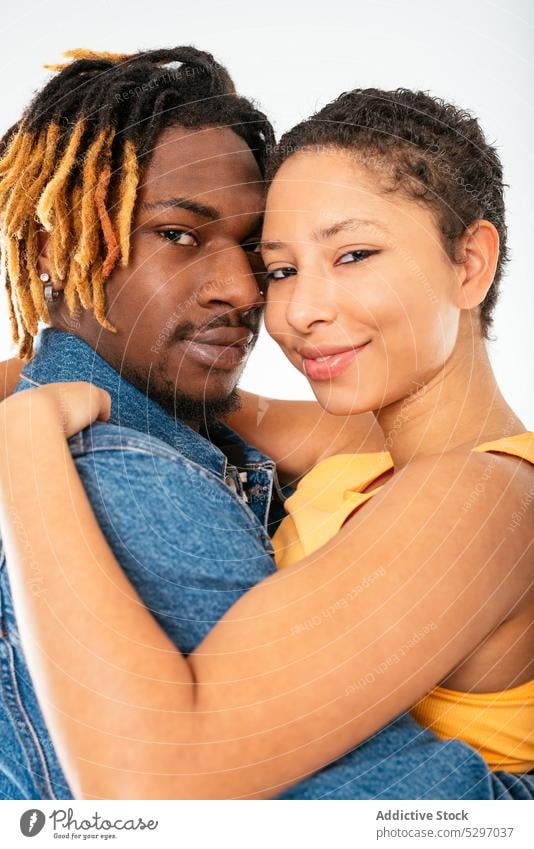 Happy ethnic couple embracing on white background boyfriend girlfriend smile relationship embrace hug happy jeans street style cheerful denim african american