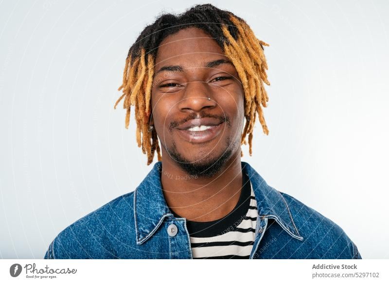 Stylish black man with dreadlocks in denim jacket style outfit smile street style cool studio shot confident african american ethnic casual positive appearance