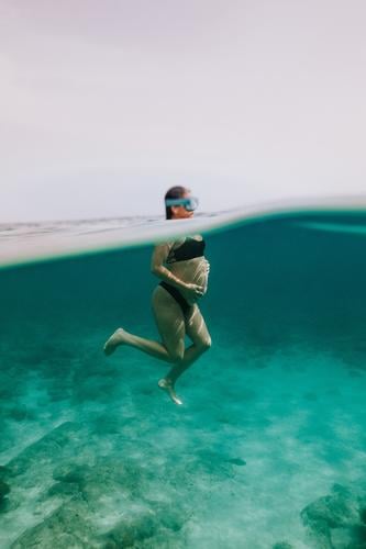 Unrecognizable pregnant woman diving in sea swim underwater fish dive undersea vacation bikini female transparent blue holiday reef enjoy belly exotic ocean