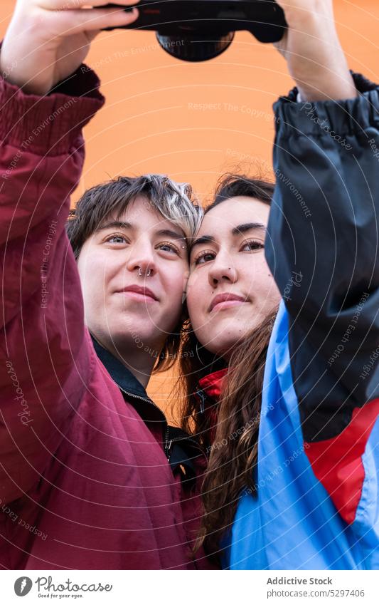 Young lesbian couple taking selfie on film camera photo camera memory take photo lgbt love relationship positive young homosexual girlfriend photography moment