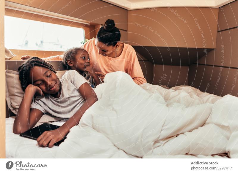 Happy black mother and children having fun in bed play smile rest positive weekend together happy ethnic african american parent sibling daughter son cheerful