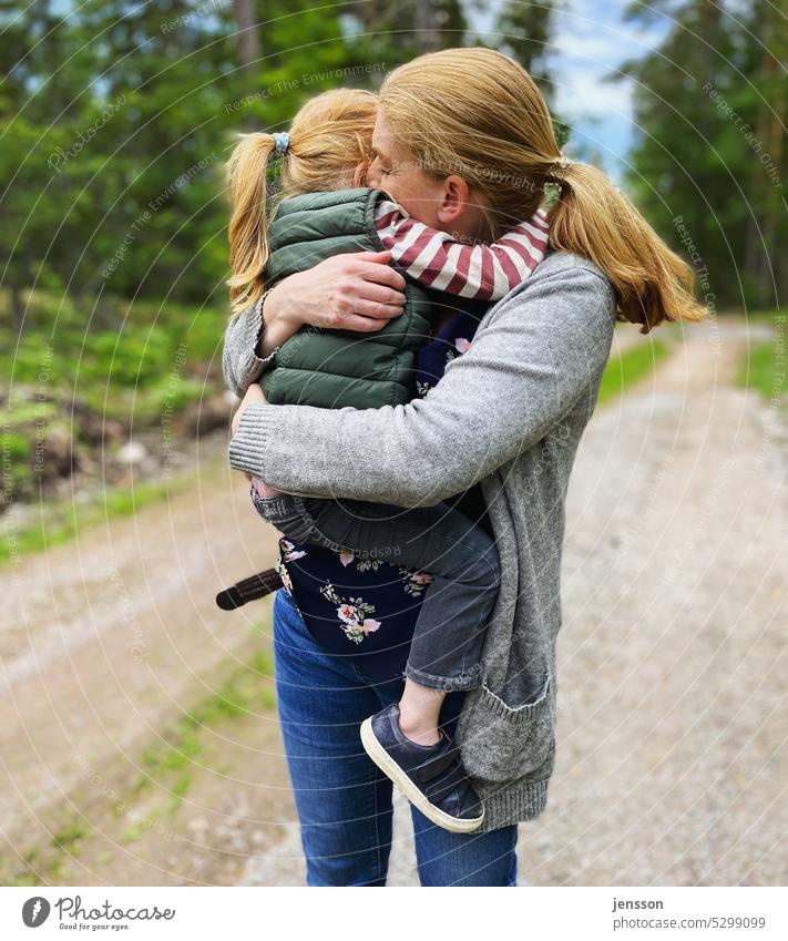 A mother cuddles with her daughter in her arms heartfelt Familiar Trust Safety (feeling of) sheltered Mother Mother with child Motherly love Maternal feelings