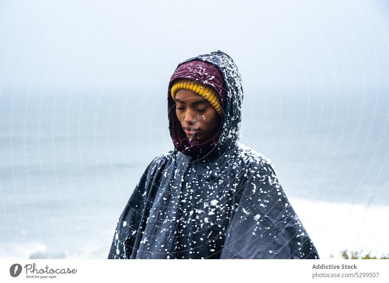 woman tourist in raincoat covered with snow traveler hoodie vacation explore admire nature sky stormy idyllic weather cloudless wanderlust alone harmony tourism