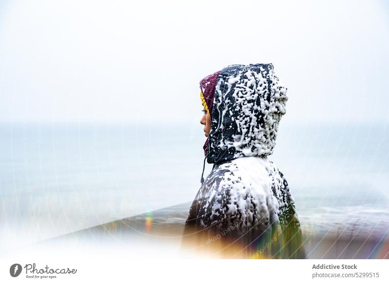 tourist in raincoat covered with snow traveler hoodie vacation explore admire nature sky stormy idyllic weather trip cloudless wanderlust alone harmony tourism