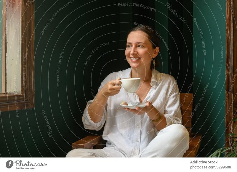 Smiling woman enjoying coffee in cafe drink positive beverage happy relax cheerful female young chair vietnam smile wooden cup rest aromatic delicious hot drink