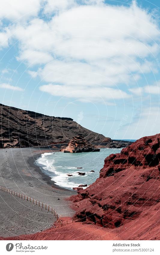 Picturesque view of rocky seashore with blue sky cloudy nature highland beach sand mountain seascape green lake laguna de los clicos lanzarote lago verde spain