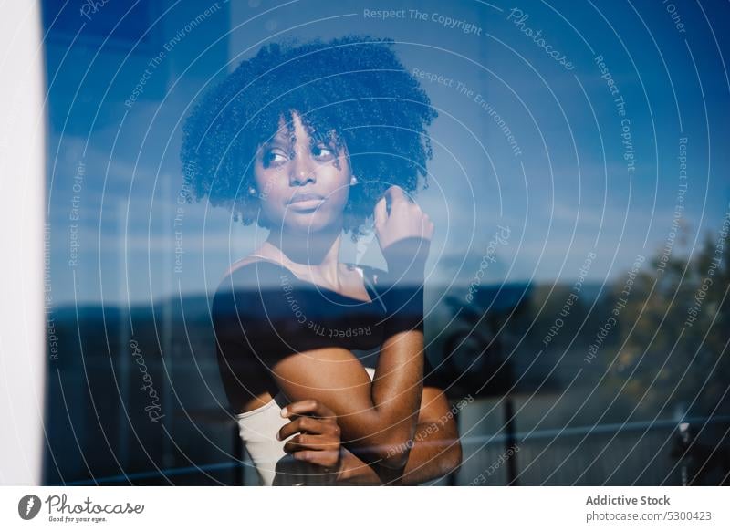 Trendy black woman looking at away near window calm serious afro pensive reflection hairstyle home female african american woman young thoughtful curly hair