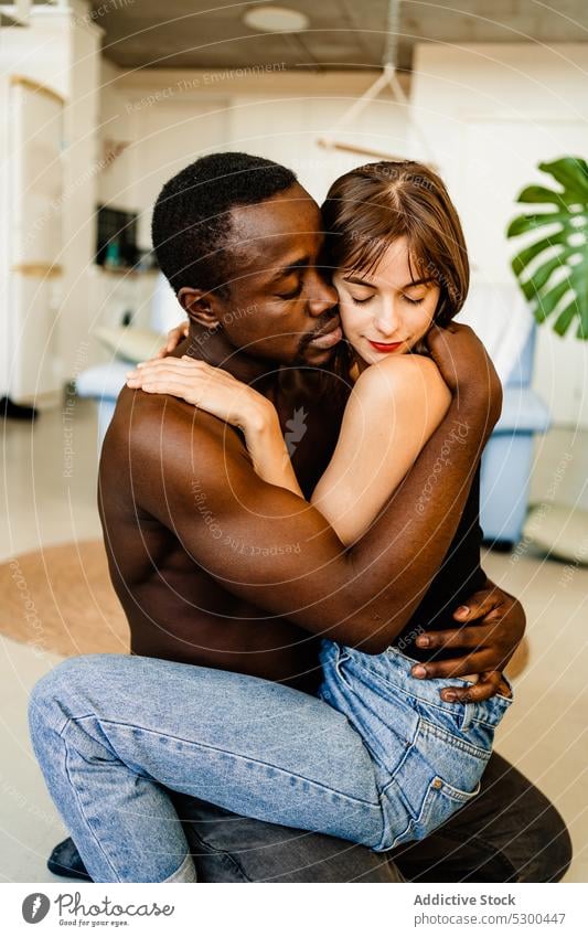 Loving multiethnic couple hugging at home love romantic embrace diverse bonding affection sensual relax relationship together multiracial woman girlfriend