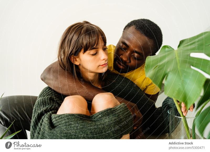 Pensive diverse couple hugging on stairs relationship love embrace staircase together young multiethnic multiracial cuddle affection casual plant boyfriend